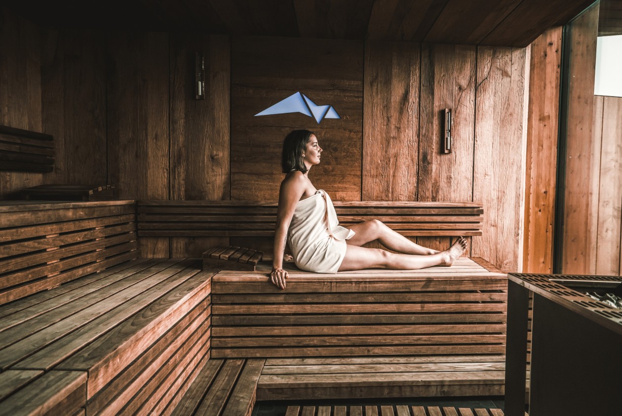 Entspannung in der Panoramasauna – Wellness im Hotel Panoramic Lotsch Südtirol Frau entspannt in der Panorama-Sauna aus naturbelassenem Holz im Hotel Panoramic Lotsch, Sarntal – wohltuende Wärme und Ruhe inmitten der Südtiroler Berge.