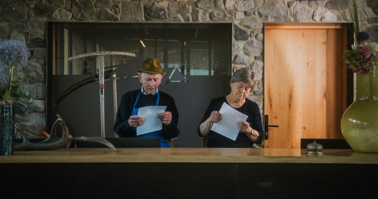 Zwei Gastgeber an der Rezeption im Wellnesshotel Panoramic Lotsch im Sarntal, stilvoller Empfangsbereich für Paare, Ruhesuchenden und Aktivurlauber in Südtirol