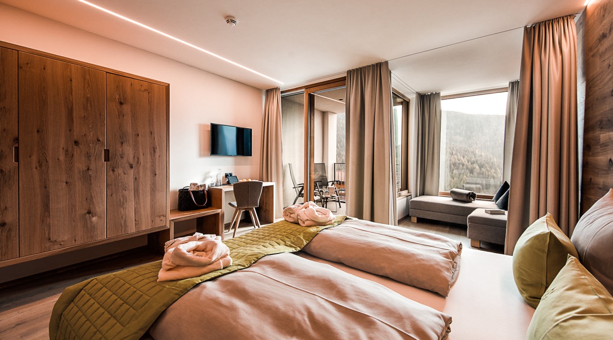 Ruhiges Doppelzimmer mit Aussicht und Komfort Modernes, ruhiges Zimmer im Hotel Panoramic Lotsch mit Blick ins Tal und gemütlichem Sitzbereich