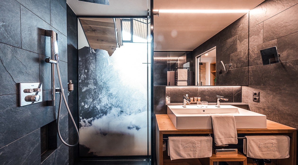 Elegantes Bad mit Regendusche – Wellnesskomfort im Hotel Panoramic Lotsch, Südtirol Modernes Badezimmer mit großer Dusche und Doppelwaschbecken im Hotel Panoramic Lotsch – ideal für ruhige Wellness-Momente im Sarntal.