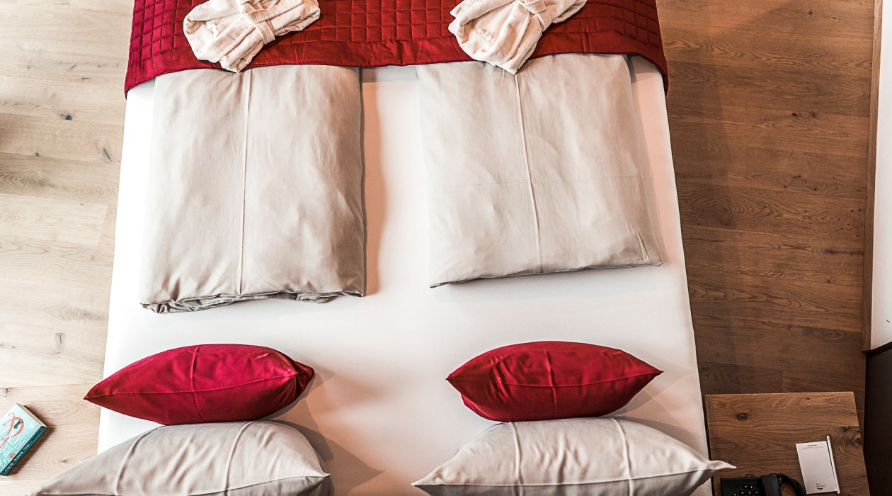 Two neatly placed spa robes on the bed of a stylish double room at Hotel Panoramic Lotsch – ideal for quiet and active days in South Tyrol’s Sarntal.