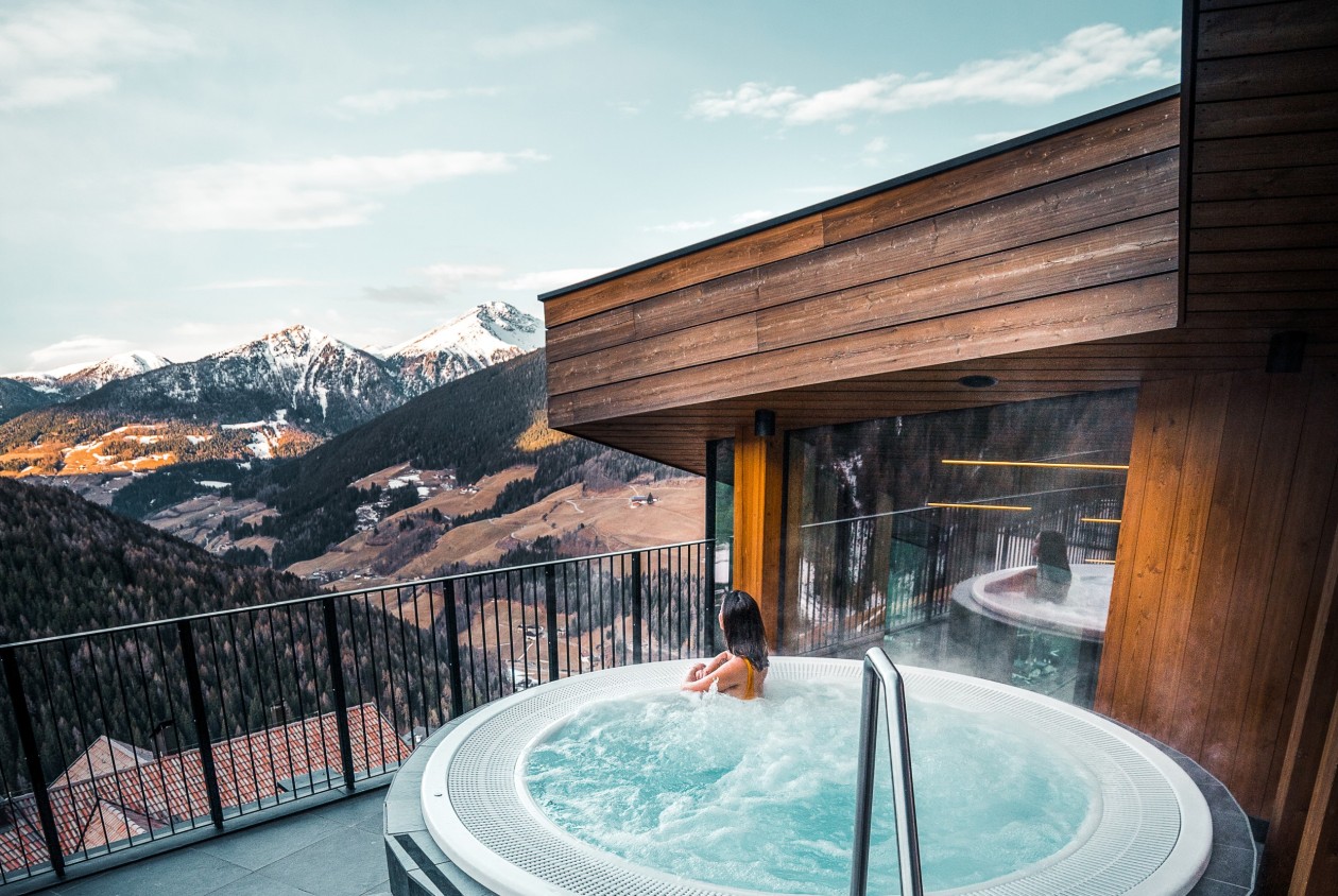 Outdoor whirlpool with panoramic views of the South Tyrolean mountains at Hotel Panoramic Lotsch in the Sarentino Valley – relaxing in warm water with a view.