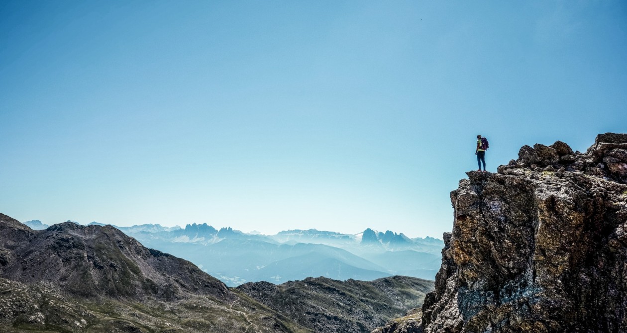 Escursionista sulla vetta con vista sulle Dolomiti – vacanza attiva nel Sarentino in Alto Adige