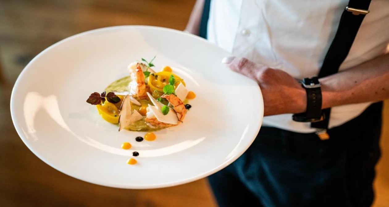 Gourmetküche im Panoramic Lodge – Südtiroler Genuss serviert mit Stil Fein angerichtetes Gourmetgericht auf weißem Teller, serviert vom Personal des Hotels Panoramic Lodge im Sarntal – Genussmomente aus der regionalen Küche Südtirols.