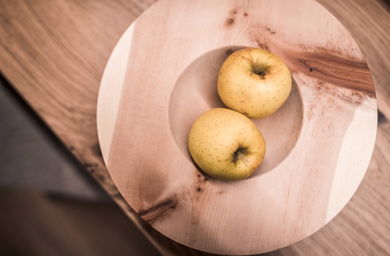 Two South Tyrolean apples in a wooden bowl at Hotel Panoramic Lotsch – a calm and local welcome in the Sarntal Valley