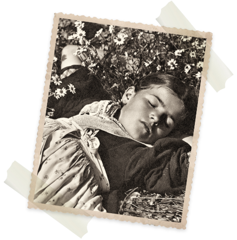 Damals wie heute: Ruhe findet man draußen Historisches Foto eines schlafenden Mädchens auf einer Blumenwiese – Sinnbild für Ruhe, Naturverbundenheit und Entschleunigung im Panoramic Lotsch