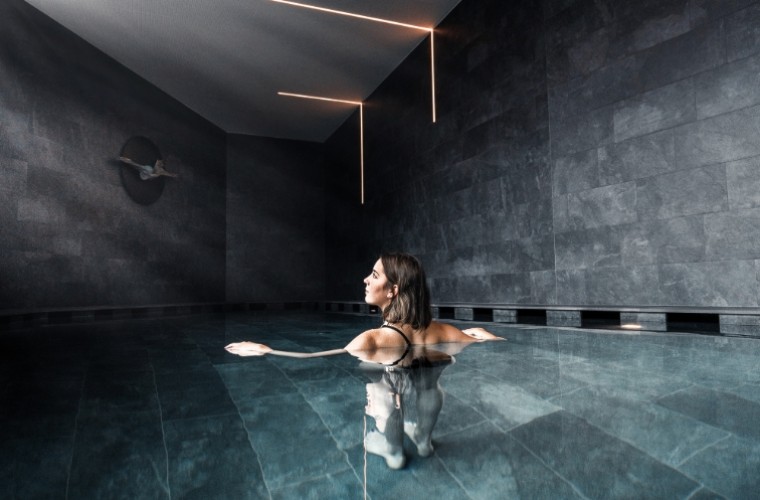 Frau entspannt allein im stilvollen Indoor-Pool des Hotels Panoramic Lotsch – ruhige Atmosphäre, Wellness & Rückzug im Sarntal