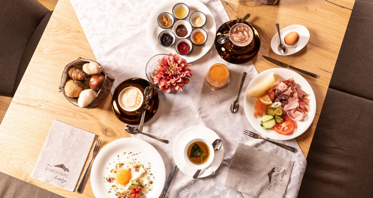 Frühstückstisch im Hotel Panoramic Lotsch, Sarntal – mit Cappuccino, frischen Brötchen, Marmeladen, Aufschnitt und regionalen Spezialitäten. Ein ruhiger Start in den Tag in Südtirol.