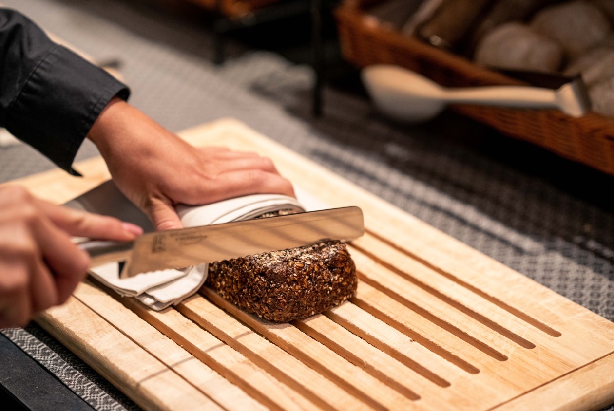Frisches Brot wird von Hand geschnitten im Hotel Panoramic Lotsch, Sarntal – regionale Backkunst als Teil eines natürlichen Frühstückserlebnisses in Südtirol.