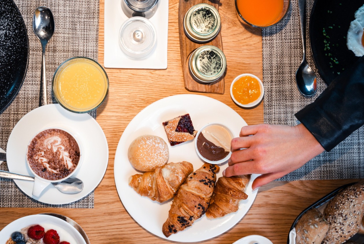 Genussvolles Frühstück im Hotel Panoramic Lotsch – Südtiroler Morgen im Sarntal Frühstücksteller mit Croissants, Aufstrichen und Fruchtsäften im Hotel Panoramic Lotsch – aktiver Start in den Tag mit ruhigem Genuss im Sarntal.