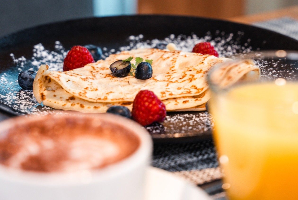Frische Crêpes mit Beeren, Kakao und Orangensaft – Frühstück im Hotel Panoramic Lotsch, aktiv und ruhig gelegen im Sarntal in Südtirol.