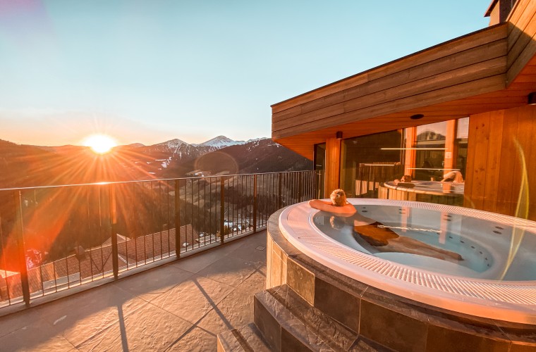 Frau entspannt im Whirlpool mit Panoramablick auf die Berge – Wellnesshotel Panoramic Lotsch, Sarntal